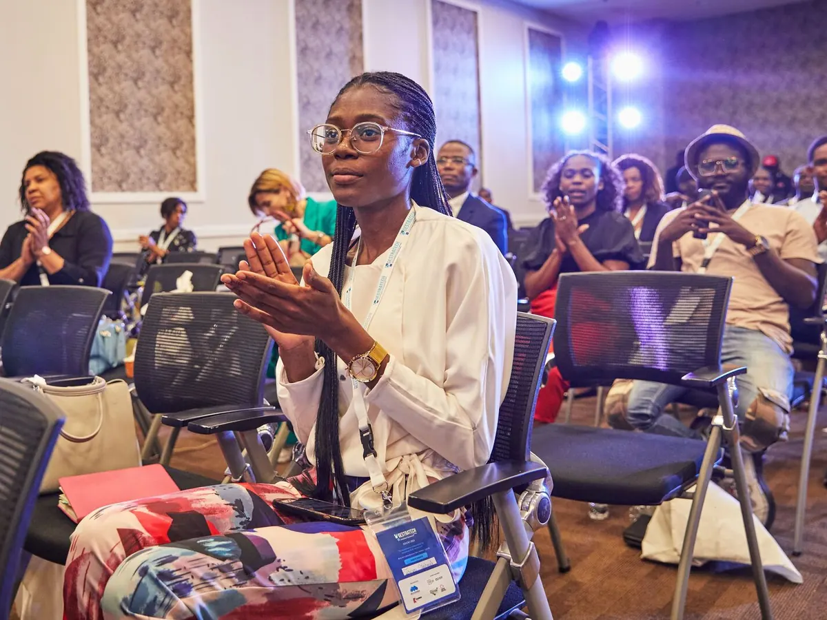 Educators in the audience applaud at a live event